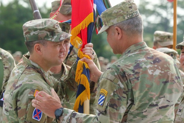 Major General Charles Costanza (right) passes the Brigade colors to Col. James Armstrong during the change of command ceremony on Fort Stewart, Georgia May 31, 2023. The passing of the colors is a time-honored tradition signifying the passing of responsibility from the outgoing commander to the incoming commander.