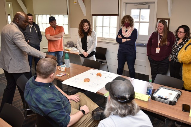 Instructor Bryan Rush (left) analyzes donut art during the Creative and Innovative Thinking Class portion of the New Employee Onboarding Course in March at Countee Hall. The next course is set for June 27 to 30. 