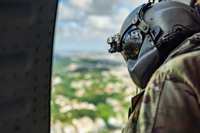 Puerto Rico National Guardsman, Staff Sgt. Ramses Trujillo Adames, crew chief with A Co. 169th General Support Aviation Battalion, looks out the window of a UH-60 Blackhawk during a casualty evacuation mission during phase two of exercise CENTAM Guardian 2023 (CG23) in Santo Domingo, Dominican Republic, May 26, 2023. CG23 is an annual Army-led combined, joint, interagency, multi-national partnership-building exercise designed to build capacity, capabilities and interoperability with Central American and Caribbean partner nations. 
