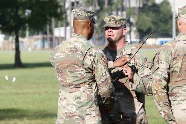 Command Sergeant Major Ray L. Kinney Jr., the newest senior enlisted leader for the 48th Infantry Brigade Combat Team receives the noncommissioned officer&#39;s sword from Colonel Jason Baker, the brigade commander, during a change of responsibility ceremony June 2, at Donovan Field on Fort Stewart.