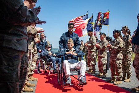 World War II veterans Wilbur Myers and Alan Dunn are welcomed by soldiers assigned to the 4th Infantry Division and 29th Infantry Division as they arrive for the D-Day 79 commemoration ceremonies in Normandy, France, June 1, 2023.