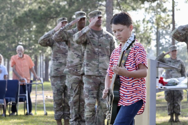 Jackson Gilbeau, son of Georgia Army National Guard Sergeant First Class Adam Gilbeau plays the National Anthem on his guitar during a change of responsibility ceremony for the 48th Infantry Brigade Combat Team June 2 at Fort Stewart.
