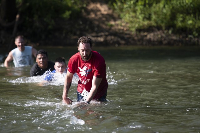 Drew Reichert, a physical scientist at the Maneuver Support Center of Excellence Homeland Defense Civil Support Office, leads a group of runners across the final water obstacle near Happy Hollow at the 22nd Marine Corps Volkslauf 10K fun run on...