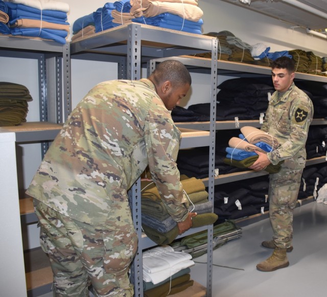 Pvt. Joshua Cotton, 3rd Cavalry Regiment, and Pfc. Michael Clark, 15th Military Intelligence Battalion, help organize linen Thursday at the Installation Reception Center. Both Soldiers arrived the night before. (U.S. Army photo by Janecze Wright,...