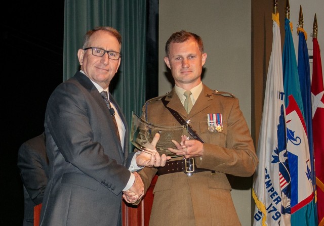 Major (United Kingdom) Edward M. Brecht receives the General Dwight D. Eisenhower Award from Gen. (Ret.) Robert B. Abrams, honoring him as the top international student in Combined and General Staff Officers Class 2023 at graduation, June 9, at the Lewis and Clark Center.