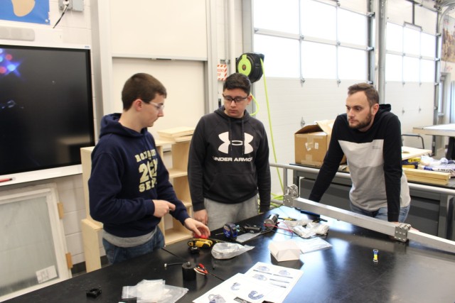 (From left to right) Mike Ratigan, Mike Lopez and Matt Brauer discuss plans for their robot for the FIRST Robotics project. FIRST Robotics is a team-based program for children 4-18 years old that encourages interest in Science, Technology, Engineering and Mathematics through hands-on learning. Brauer not only started a FIRST Robotics team at his high school when he was a senior, but also coached and now mentors the team.
