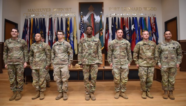 Col. Adam Hilburgh, Maneuver Support Center of Excellence chief of staff (left), and U.S. Army Chemical, Biological, Radiological and Nuclear School Regimental Command Sgt. Maj. Raymond Quitugua Jr. (right) pose for a photo with the winners of the MSCoE Best Squad Competition – from the 1st Engineer Brigade: Sgt. 1st Class Oscar Olivo, Sgt. Matthew Detmer, Spc. Zion Beaver, Spc. Collin Stageman and Spc. Sean Brown – following an awards ceremony on Friday in Lincoln Hall Auditorium. 