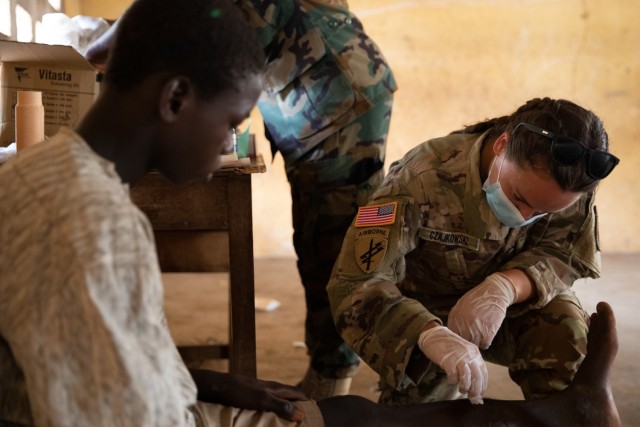 U.S. Army Sgt. Kaci Czajkowski, medic, 352nd Civil Affairs Command, treats a local child for abrasion wounds in Yendi, Ghana, June 3, 2023, during a medical civic action program as part of exercise African Lion 2023.