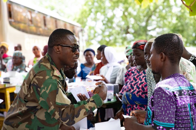 A Ghana Army soldier collects medical information from a local child in Yendi, Ghana, June 3, 2023, during a medical civic action program as part of exercise African Lion 2023.