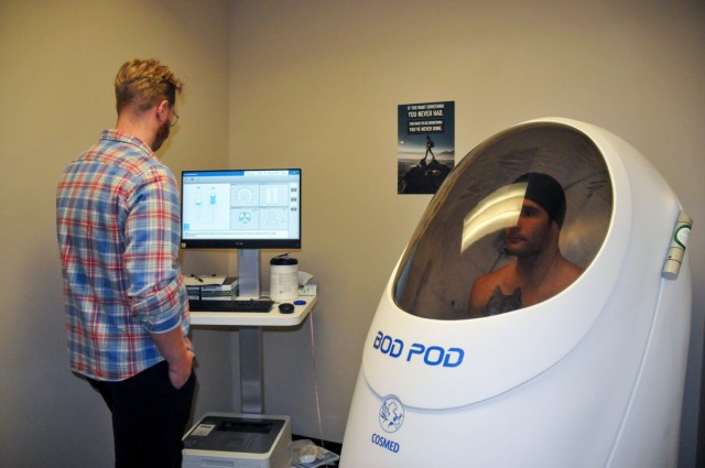 Cpt. Chance Hoggie completes a metabolic assessment in the bod pod at the Fort Leavenworth Army Wellness Center while Brooks Roth, a health educator, oversees the test.