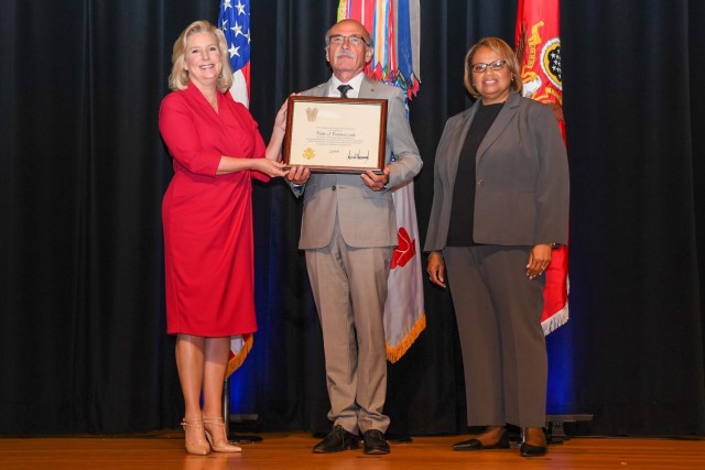 Dr. Piotr Franaszczuk receives a Meritorious Senior Professional Award from Army Secretary Hon. Christine E. Wormuth.