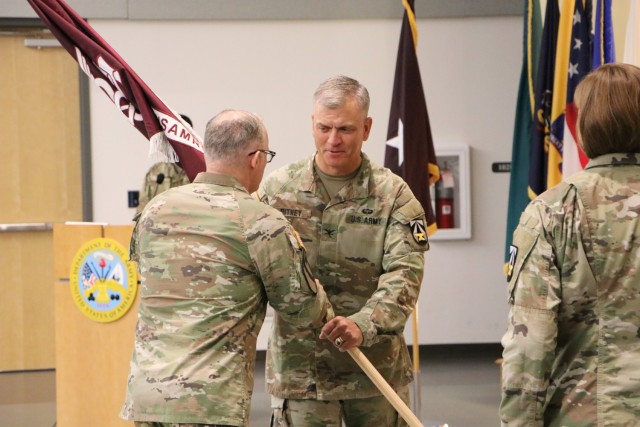Col. Aaron Pitney, incoming commander of U.S. Army Medical Research Institute of Infectious Diseases, accepts the unit guidon from Brig. Gen. Anthony McQueen, commanding general, U.S. Army Medical Research and Development Command and Fort Detrick, during a change of command ceremony June 22. (Photo by William Discher, USAMRIID Public Affairs)