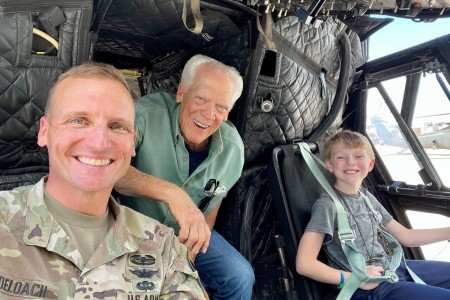 Lt. Col. Brad DeLoach sits in the cockpit of a CH-47 Chinook helicopter with his 12-year old son Robert, right, and maternal grandfather, retired Col. Edwin H. &#34;Bud&#34; Henry, center. DeLoach, who was adopted as an infant, learned about his birth family’s ties to military service and Army aviation almost three years ago through an at-home genealogy test and research through the alumni database at the U.S. Army War College.