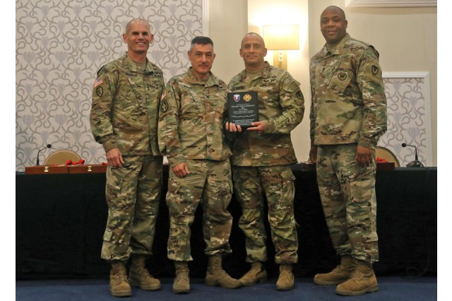 Lt. Gen. Omar Jones (left), commanding general of U.S. Army Installation Management Command, and IMCOM Command Sgt. Maj. Jason Copeland (right), present the 2023 Best Garrison Award to Col. Anthony Pollio, Fort Leonard Wood commander (second from left), and Fort Leonard Wood Command Sgt. Maj. Danny Castleberry on June 6 at Joint Base San Antonio, Texas.