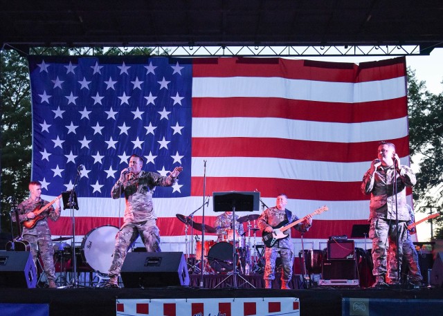 As the sun sets behind the stage Tuesday evening on Gammon Field, the 399th Army Band’s Rough Riders rock band perform a mix of rock and country songs prior to Fort Leonard Wood’s fireworks display during the installation’s Fourth of July celebration. 
