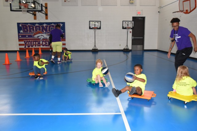 Preschoolers receive a thrill out of using scooters to simulate wheelchair basketball during the Adaptive Sports event June 30 at the Bronco Youth Center. (U.S. Army photo by Janecze Wright, Fort Cavazos Public Affairs) 