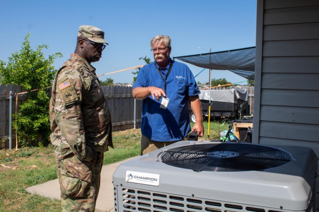 Sgt. 1st Class Edrick Kendrick, 1st Cavalry Division, listens as John Schwartz, HVAC supervisor for Cavalry Family Housing, discusses the maintenance performed on the AC unit. (U.S. Army photo by Samantha Harms, Fort Cavazos Public Affairs)