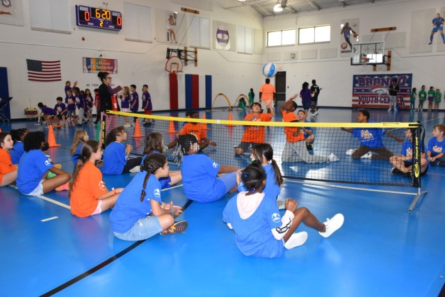 Fourth and fifth graders compete in a game of seated volleyball during the Adaptive Sports event June 30 at the Bronco Youth Center. The game simulated what it is like to play volleyball in a wheelchair or without the use of one&#39;s legs. (U.S....