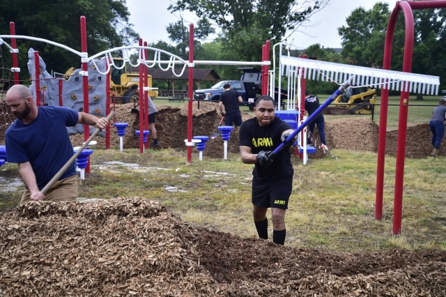 CSM Andre Welch, garrison CSM, pitch-in spreading mulch to restore KABOOM playground.