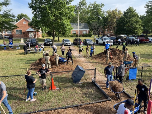 June 26, 2023 -- Fort Meade community members pitch-in spreading mulch to restore KABOOM playground.
