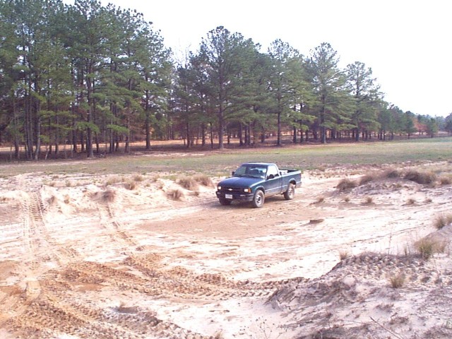A work truck sits in a helicopter landing zone in the training area at Fort Liberty, May 2002. The Integrated Training Area Management team at Fort Liberty has been implementing best practices from other installations to tackle the issue of “rotor wash” or sand erosion caused by helicopters, which has caused both environmental challenges and training difficulties for Soldiers.