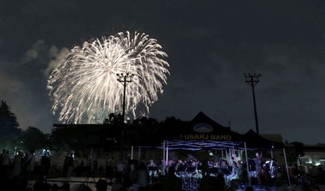 Onlookers enjoy a fireworks display during the Independence Day celebration at Camp Zama, Japan, July 1, 2023. The celebration is one of several open-post events that U.S. Army Garrison Japan staff members help organize to strengthen relationships with the local community. 