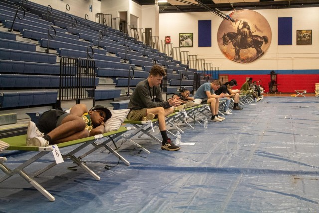 Role players relax in cots in Abrams Physical Fitness Center, following a simulated evacuation of housing residents during the full-scale exercise July 11. Some exercise evacuees were treated for heat related symptoms or transported to Carl R....