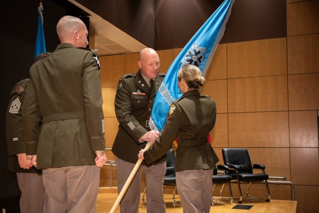 From left, Col. Eric Haas, incoming commander of the National Ground Intelligence Center stands at attention while Col. Christopher Rankin, outgoing commander, hands the brigade colors to Maj. Gen. Michele H. Bredenkamp, INSCOM commanding general. 