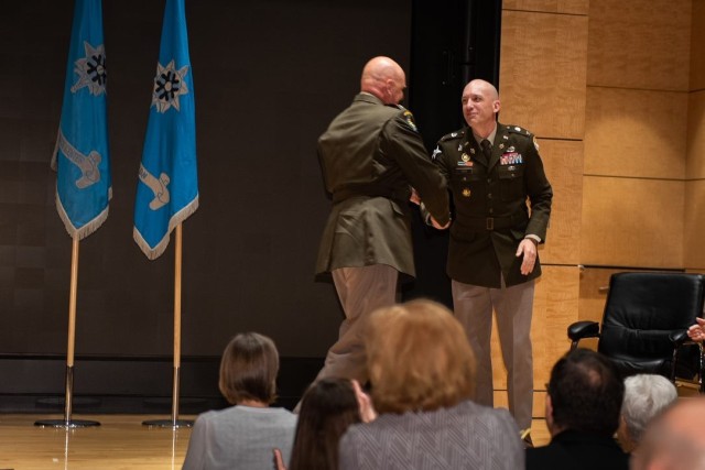 From left, Col. Christopher Rankin, outgoing commander of the National Ground Intelligence Center, congratulates Col. Eric Haas, incoming commander of the National Ground Intelligence Center. 