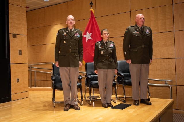 From left Col. Eric Haas, incoming commander of the National Ground Intelligence Center; Maj. Gen. Michele H. Bredenkamp, INSCOM commanding general; and Col. Christopher Rankin, outgoing commander stands at attention as the National Anthem is performed. 