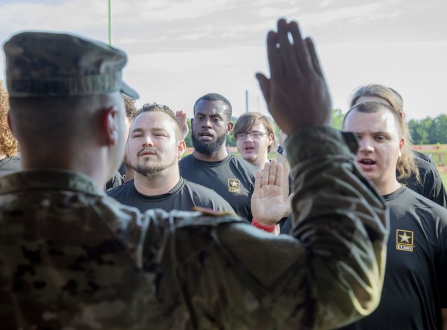 D’Wayne Thorpe (center), a U.S. Army Kansas City Recruiting Battalion recruit, recites the U.S. Army Oath of Enlistment, Aug. 18, 2022, in St. Joseph, Missouri, during the Kansas City Chiefs training camp. In partnership with the 1st Infantry Division and the KC Chiefs, the KC Recruiting Bn. swore in 18 recruits during the Chiefs Military Appreciation Day. (U.S. Army photo by Spc. Alvin Conley, 19th Public Affairs Detachment)