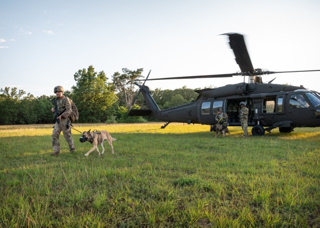 Soldiers with the 180th Military Police Detachment and their military working dogs exit a Black Hawk helicopter during a five-day field training exercise on Fort Leonard Wood. 