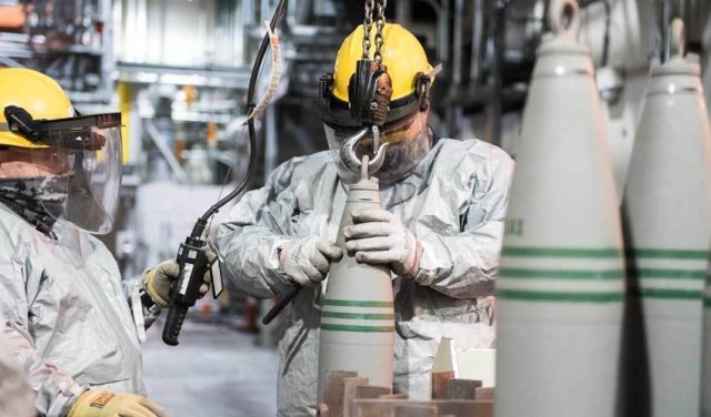 Operators lift the last palletized 155 mm projectile containing VX nerve agent to place onto a tray to begin the destruction process at the Blue Grass Chemical Agent-Destruction Pilot Plant, in Kentucky, May 2021.