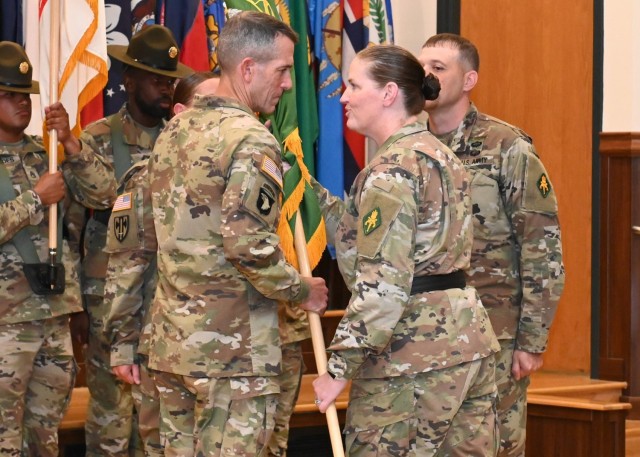 Incoming U.S. Army Military Police School Regimental Command Sgt. Maj. William Shoaf (left) takes the USAMPS colors from Brig. Gen. Sarah Albrycht, USAMPS commandant, while outgoing Regimental Command Sgt. Maj. Shawn Klosterman looks on during a change-of-responsibility ceremony Friday in Lincoln Hall Auditorium. 