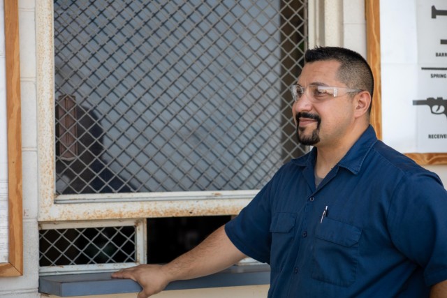 Oscar Medina, a small arms mechanic with the Army Field Support Battalion-Cavazos’ Maintenance Division, listens as a coworker speaks with him outside of their office. Medina is one of the many employees impacted by the increase. (US Army photo by Samantha Harms, Fort Cavazos Public Affairs) 

