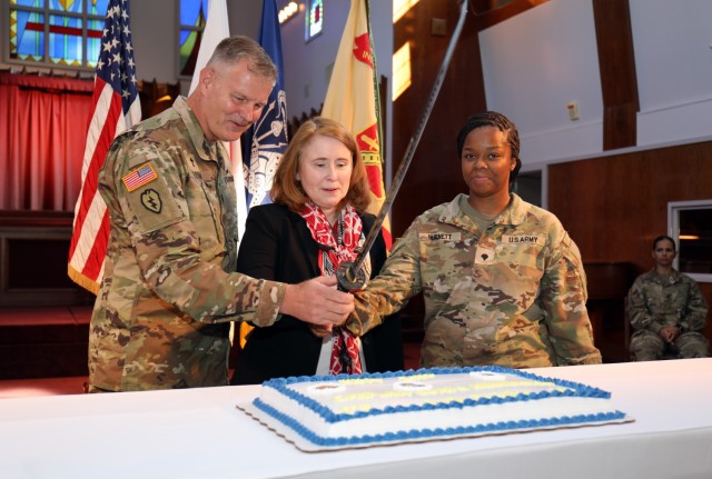 Lt. Col. Mark Olson, left, deputy command chaplain for U.S. Army Japan; Jenifer L. Peterson, center, deputy commander of U.S. Army Garrison Japan; and Spc. Jada Burnett, a religious affairs specialist, help cut a cake as part of a ceremony celebrating the Camp Zama Chapel&#39;s 70 years of service and the U.S. Army Chaplain Corps&#39; 248-year anniversary at the chapel July 28, 2023.