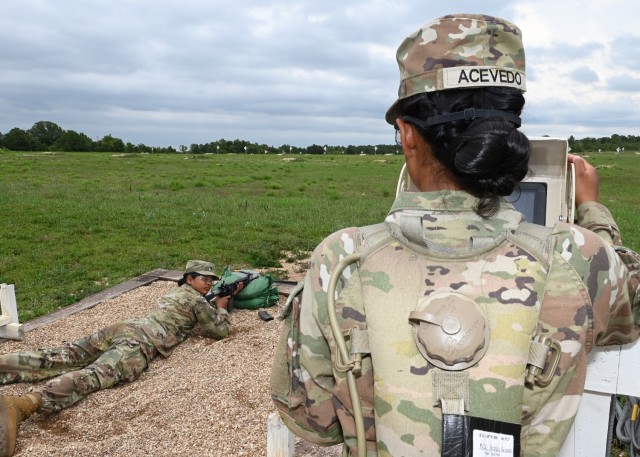 As Pvt. Diana Acevedo, a trainee with Company B, 1st Battalion, 48th Infantry Regiment, prepares to confirm the aim on her M4 rifle Wednesday on Range 11, she looks back at her fellow trainee and twin sister, Pvt. Andrea Acevedo, who acts as the...