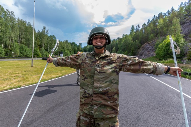 Army Reserve 1st Lt. Brianna Mirmina, Military Intelligence Readiness Command, Inter-Allied Confederation of Reserve Officers, crosses the finish line of a simulated cross-country skiing event during the Military Orienteering march.