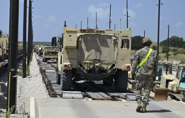 A Soldier assigned to the 3rd Cavalry Regiment loads a Joint Light Tactical Vehicle Tuesday onto a train in preparation for movement to Fort Iwrin, California.