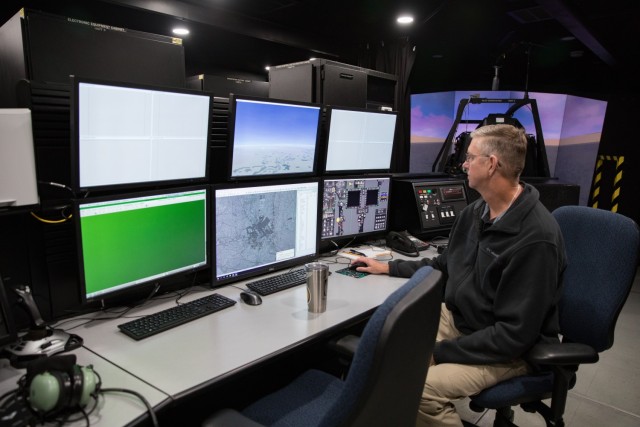 Flight Instructor/Operator Jim Campbell looks at the screens that allow him to create scenarios for pilots to train in. (U.S. Army photo by Blair Dupre, Fort Cavazos Public Affairs) 