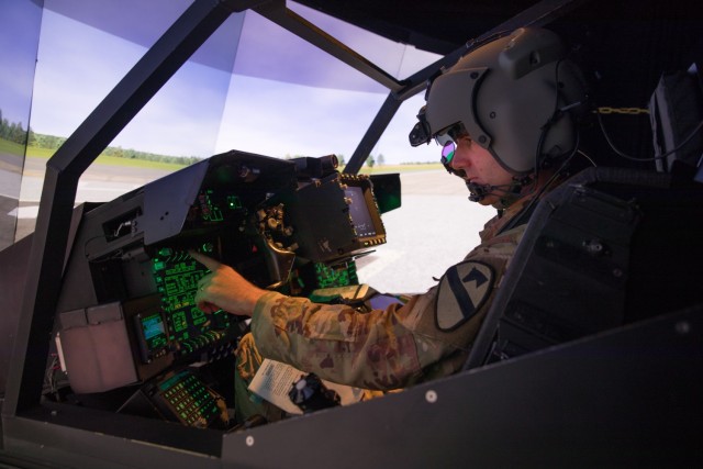 1st Lt. Harrison Ryder, Delta Troop, 7th Bn., 17th Cav. Regt., prepares for flight in an AH-64E Longbow Crew Trainer simulator July 26 at the Flight Simulation Division. 