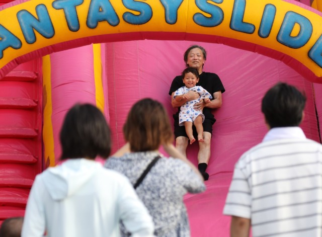 Japanese guests enjoy a children&#39;s attraction during the Bon Odori festival at Camp Zama, Japan, Aug. 5, 2023. About 20,000 people attended this year&#39;s event, which honors the departed spirits of one’s ancestors. The traditional Japanese festival has been celebrated at Camp Zama since 1959.
