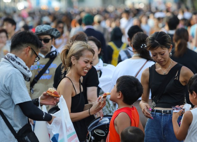 Japanese guests try some pizza during the Bon Odori festival at Camp Zama, Japan, Aug. 5, 2023. About 20,000 people attended this year&#39;s event, which honors the departed spirits of one’s ancestors. The traditional Japanese festival has been celebrated at Camp Zama since 1959.