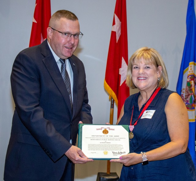 Dr. Kathleen Hersey, spouse of Maj. Gen. Neil S. Hersey, U.S. Army Cyber Command Deputy Commanding General-Operations, accepts the Army Meritorious Public Service Medal during Maj. Gen. Hersey's retirement ceremony at the Georgia Cyber Center in...