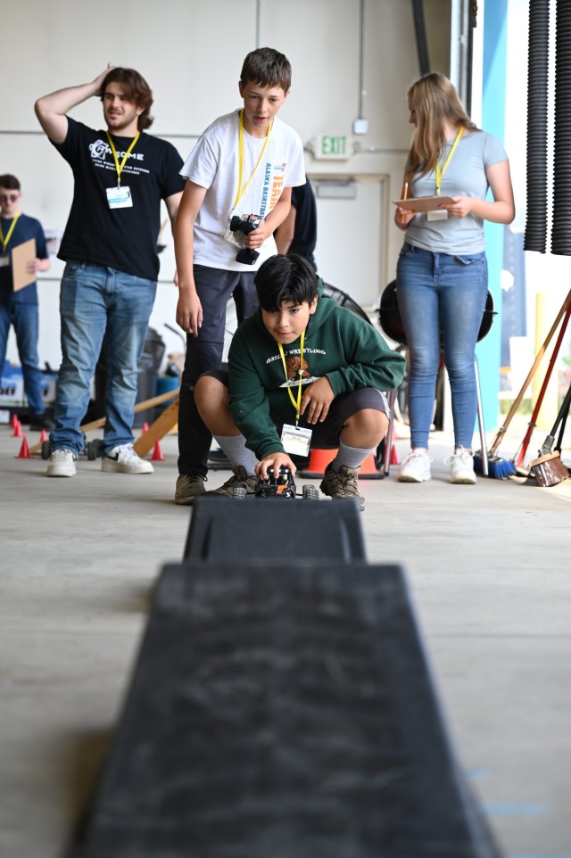 Delta Junction students Oliver Javalera, Keegan Enderle, Aubrey Bialik and Michael Davis, team mentor, enjoy a remote-control car race as part of a vehicle acceptance experiment during a weeklong STEM camp hosted by U.S. Army Cold Regions Test Center Aug. 1-4. 