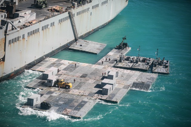 Army mariners assigned to the 368th Seaport Operations Company and 331st Transportation Company construct a causeway adjacent to the MV Maj. Bernard F. Fisher off the coast of Bowen, Australia, July 29, 2023. When complete, the causeway will form a floating pier enabling the discharge of vehicles from the Fisher to shore demonstrating the critical capability of Joint Logistics Over-the-Shore during Talisman Sabre. Talisman Sabre is the largest bilateral military exercise between Australia and the United States, with multinational participation, advancing a free and open Indo-Pacific by strengthening relationships and interoperability among key allies and enhancing our collective capabilities to respond to a wide array of potential security concerns. 
