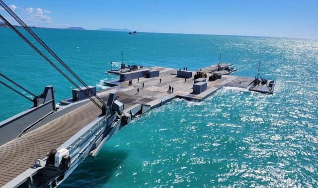 Army mariners assigned to the 368th Seaport Operations Company and 331st Transportation Company construct a causeway adjacent to the MV Maj. Bernard F. Fisher off the coast of Bowen, Australia, July 29, 2023. When complete, the causeway will form a floating pier enabling the discharge of vehicles from the Fisher to shore demonstrating the critical capability of Joint Logistics Over-the-Shore during Talisman Sabre. Talisman Sabre is the largest bilateral military exercise between Australia and the United States, with multinational participation, advancing a free and open Indo-Pacific by strengthening relationships and interoperability among key allies and enhancing our collective capabilities to respond to a wide array of potential security concerns. 