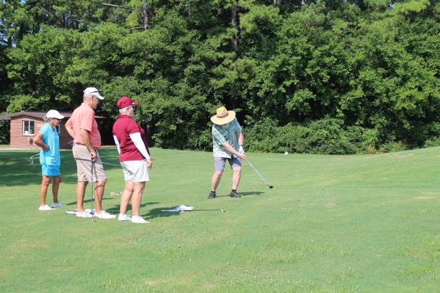Floyd Parks uses a sand wedge for a chip shot on Patriot No. 9 during Saturday’s Garrison Scramble at the Links. His teammates looking on, from left, are Phyllis Hopson, her husband Charlie, and Floyd