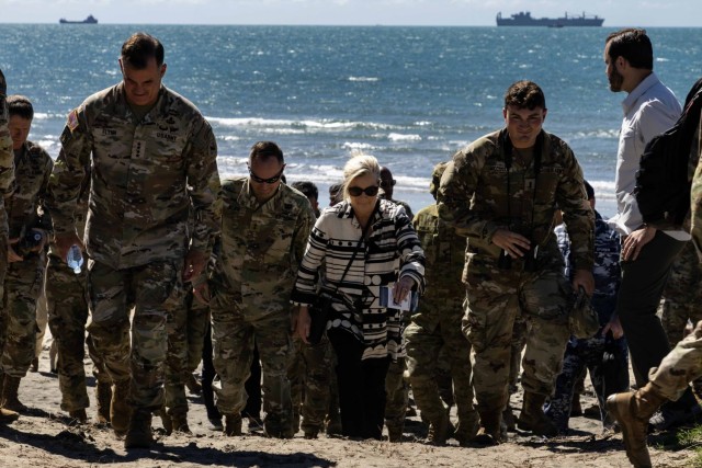 The Secretary of the Army Christine Wormuth, center, walks up a dune surrounded by Army leaders and staff during Talisman Sabre 2023 to observe and receive briefs on Joint Logistics Over-the-Shore in Bowen, Australia, July 29, 2023. Joint Logistics Over-the-Shore is the critical capability of discharging vehicles and equipment onto shore when port facilities are either unavailable or damaged. 