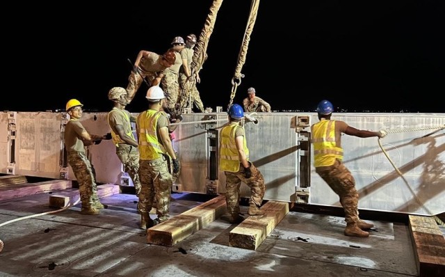 Service members assigned to the Joint Logistics Over-the-Shore operation of Talisman Sabre 23 prepare equipment to be moved from ship to the shore. The team used a causeway ferry to shuttle vehicles and equipment to the beach landing site.